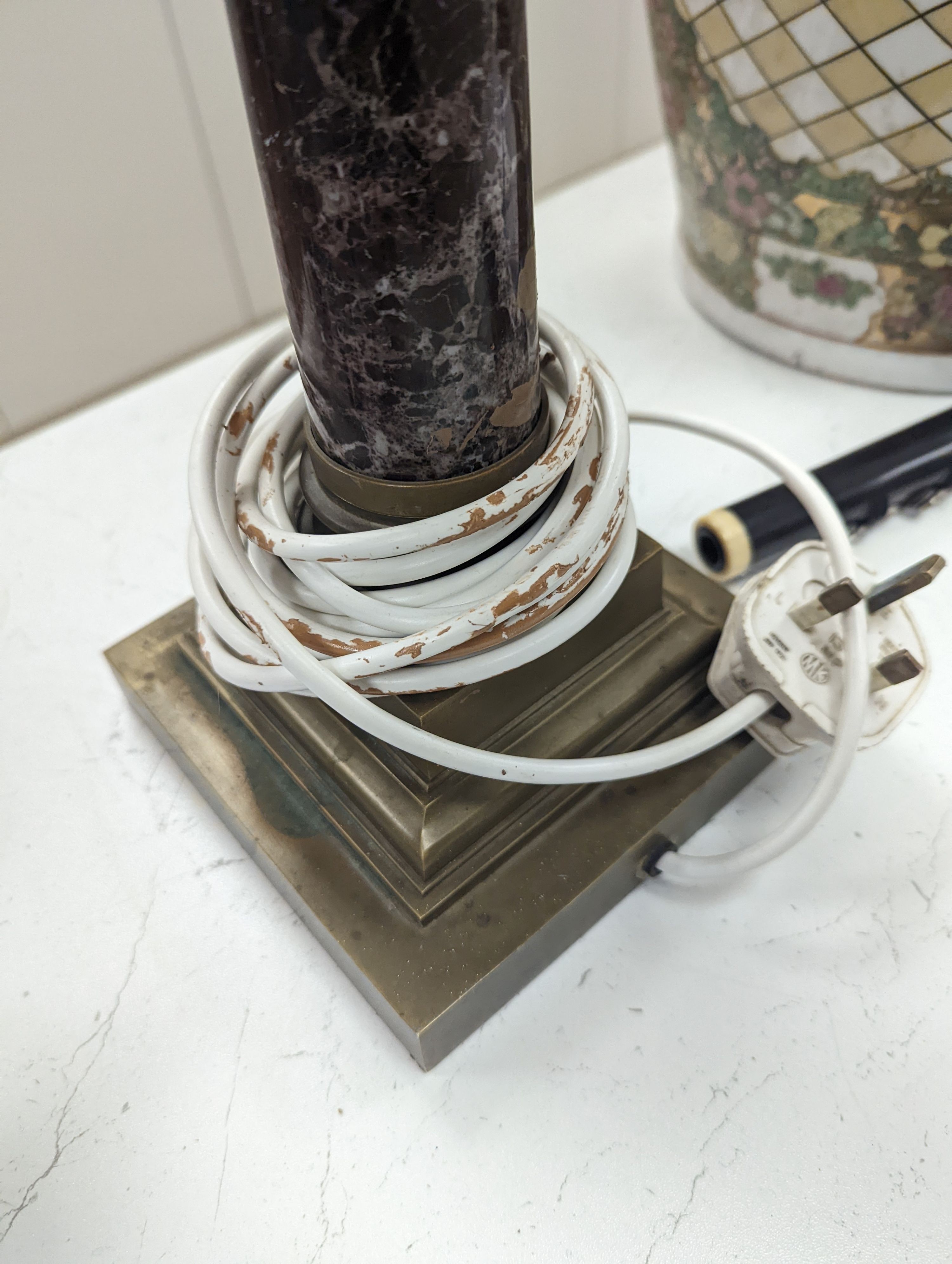 A brass and variegated marble Corinthian column lamp base, 47cms high, not including light fitting.